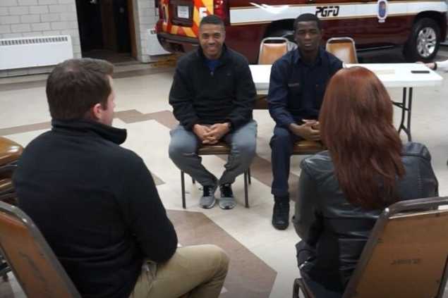 four people sitting in chairs talking