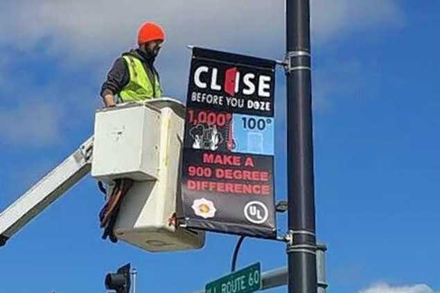 public works crew member installing banners on telephone poles