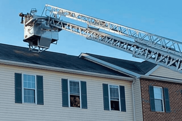 tower ladder extended to the roof of a house