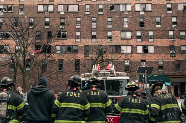 firefighters standing in front of apartment building